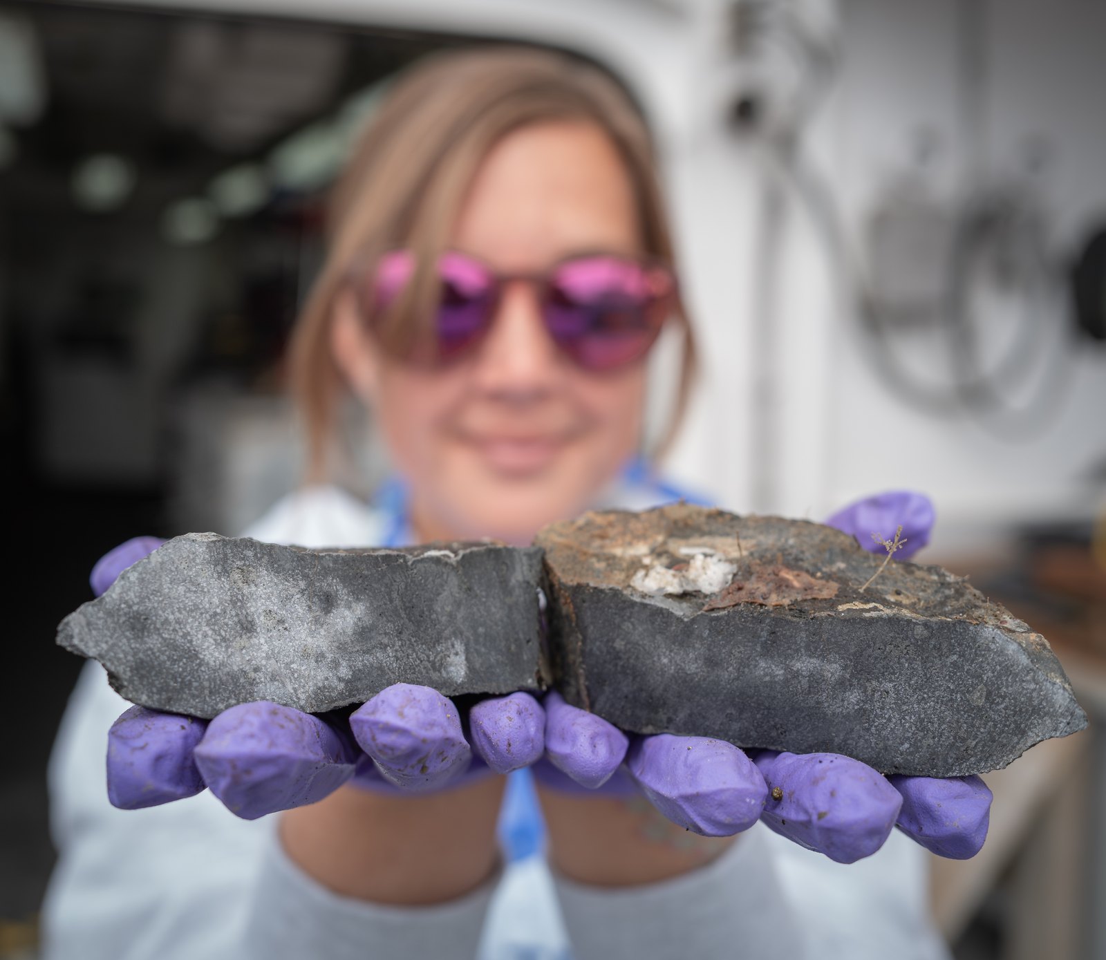 USGS scientist Katlin Adamczyk holds up rock samples from Aleutian Islands seafloor