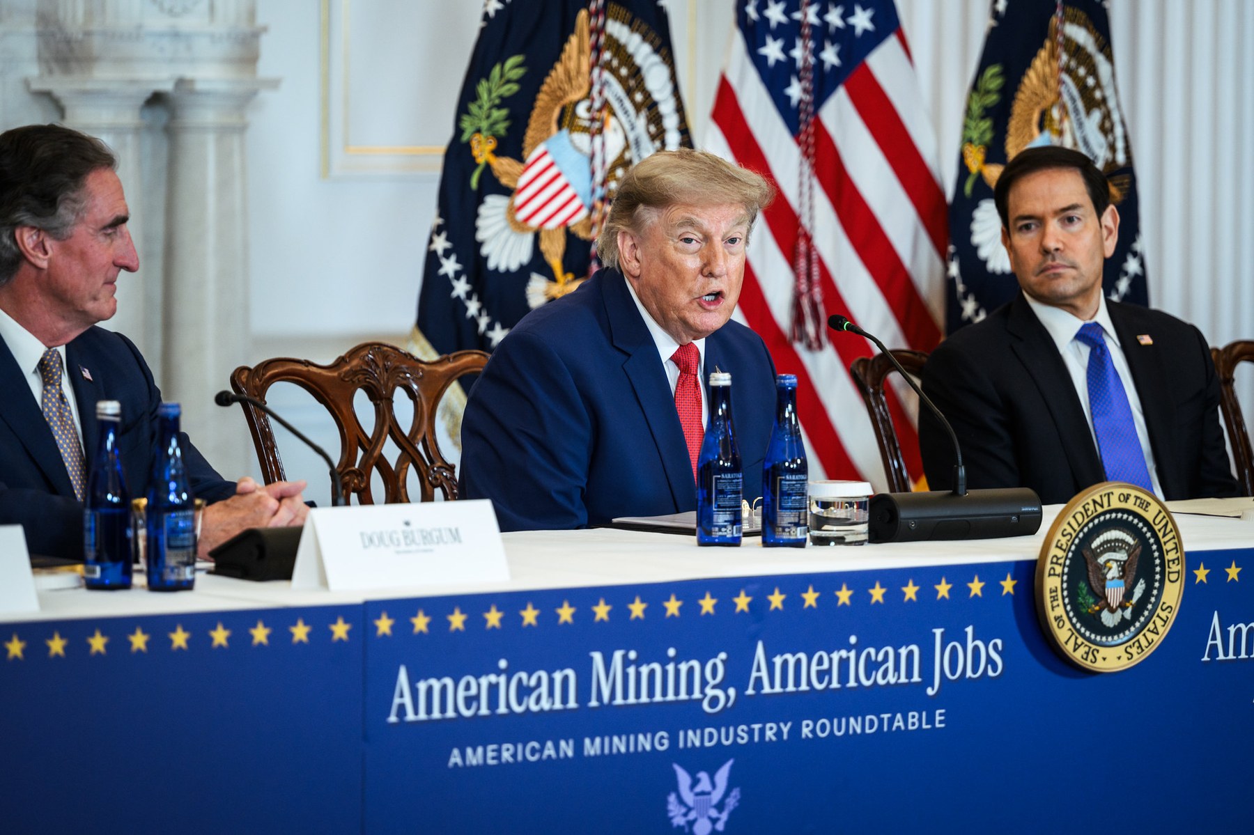 President Trump at the American Mining Roundtable flanked by Secretary Rubio and Secretary Burgum