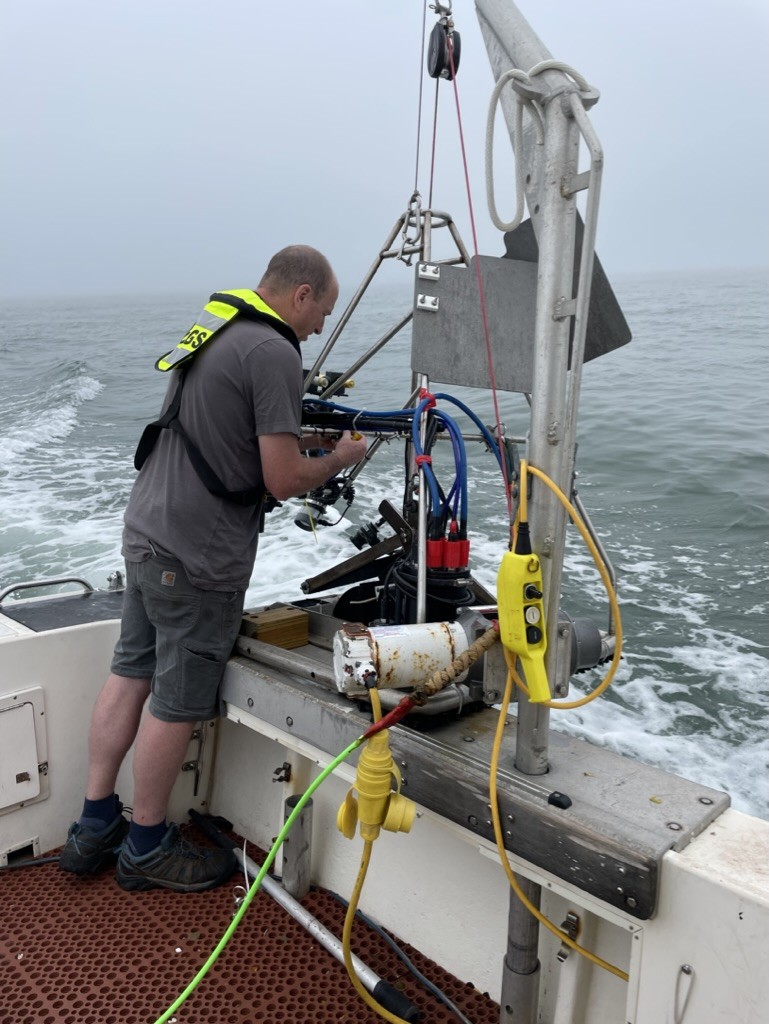 Person on back of boat in the ocean handling equipment
